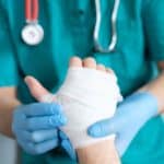 Nurse putting bandage on patients hand